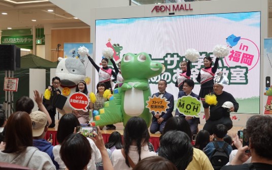 「ブラックワニーサ軍襲来！お金の知識で世界を平和に」出演のタレントやワニーサ等がステージでポーズをとっている様子