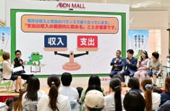 お金の知識について講師と出演者のやり取りを大人が見ている様子