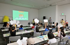 うんこお金ドリル経済編の問題に子供が回答札を上げている様子