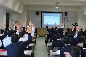 財政についての講義をする講師と挙手する生徒たち