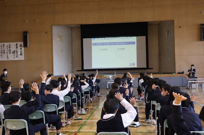 スクリーンを見ながら手を挙げて質問に答える生徒達（前田中学校）