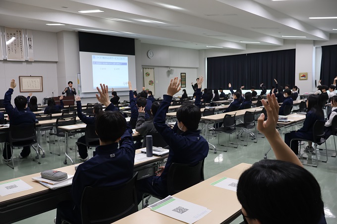 講師の出したクイズに手を挙げて答える生徒たち（中島中学校）