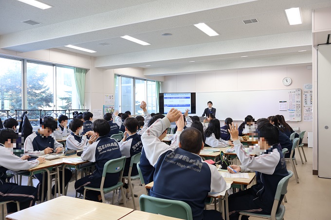 質問する講師に手を挙げて答える生徒達の様子（星蘭中学校）
