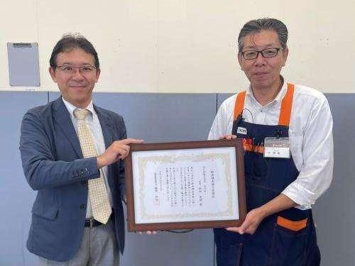 贈呈後に感謝状を掲げる店長と所長