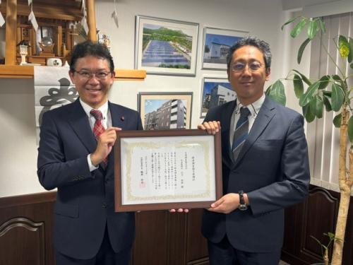 贈呈後に感謝状を掲げる代表取締役と所長
