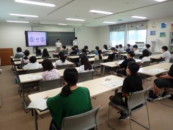 日本の財政について説明する講師と説明を聞く児童