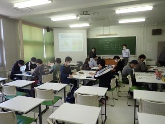 日本の財政について説明する職員と説明を聞く学生