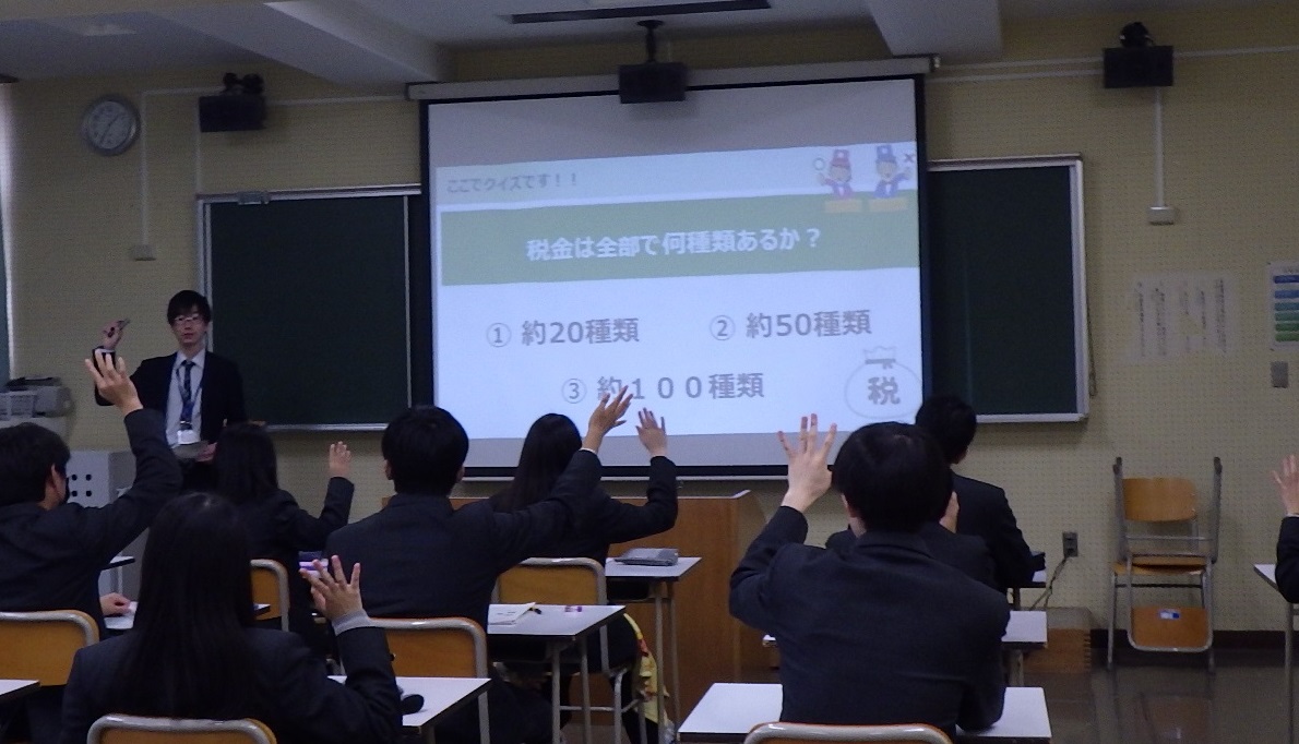 財政についての講義を受け、挙手で質問に答える生徒たち