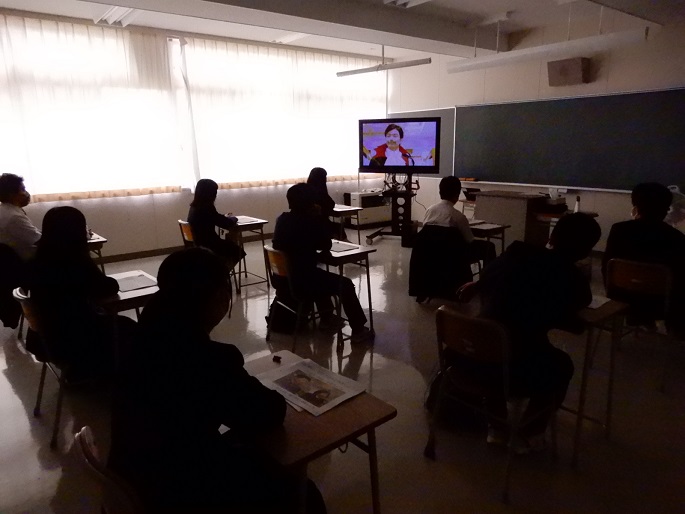 テレビ画面に映し出される財政のビデオを見ている生徒たちの様子