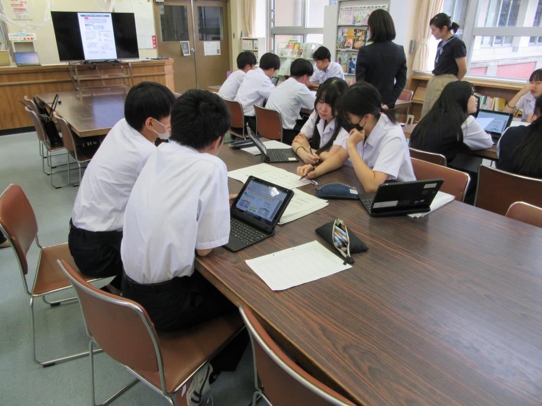 生徒４人がタブレットを使用しながらグループワークに取り組む様子