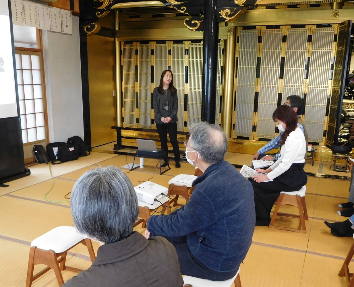 財務事務所の女性職員がお寺で高齢者を対象に特殊詐欺等の被害防止セミナーを行っている様子