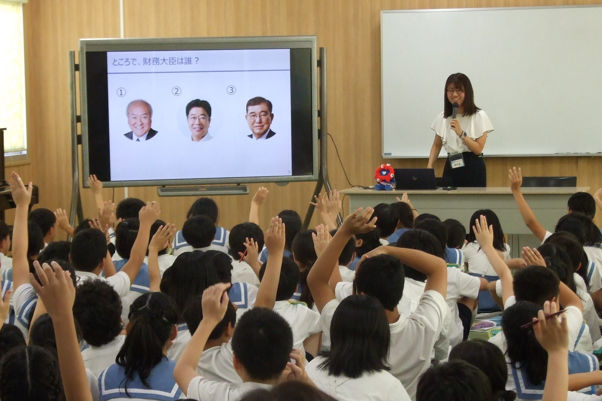 財政教育プログラムで講師がクイズを交えて講義をしている