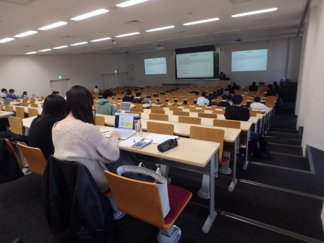 多数の学生が東北大学の講義室で東北財務局長の講義を聞いている様子