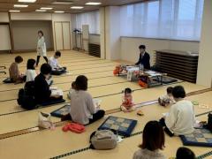秋田財務事務所の職員の講座を参加者が子ども連れで聞いている様子