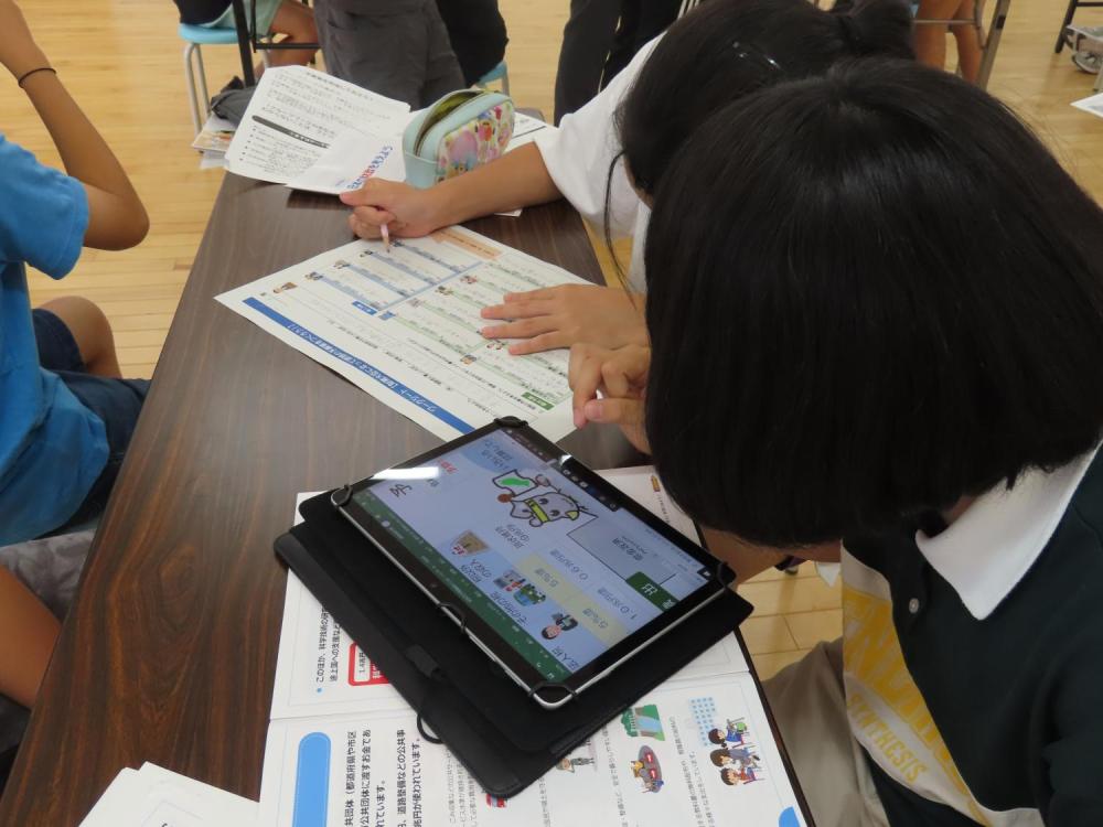 児童たちがタブレットを使用し、グループで国の予算についてシミュレーションしている様子