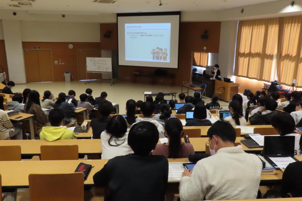 財務局職員がモニターに投影したスライドを使用し財政の説明を行っている様子