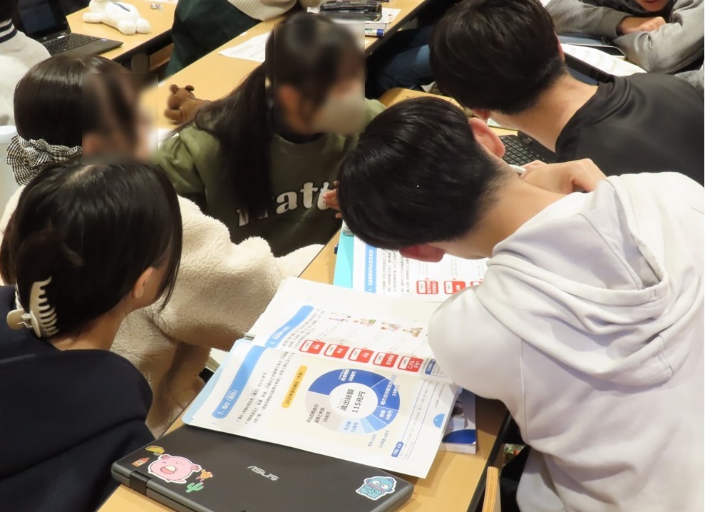 生徒同士がタブレットを使用しながらグループワーク形式で予算編成のシミュレーションに取り組む様子