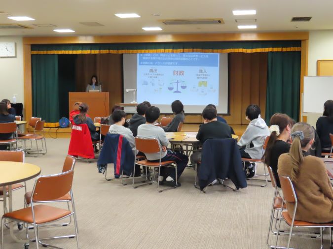 スクリーンに資料を投影し、講師が資料を説明しながら講義を行っている様子