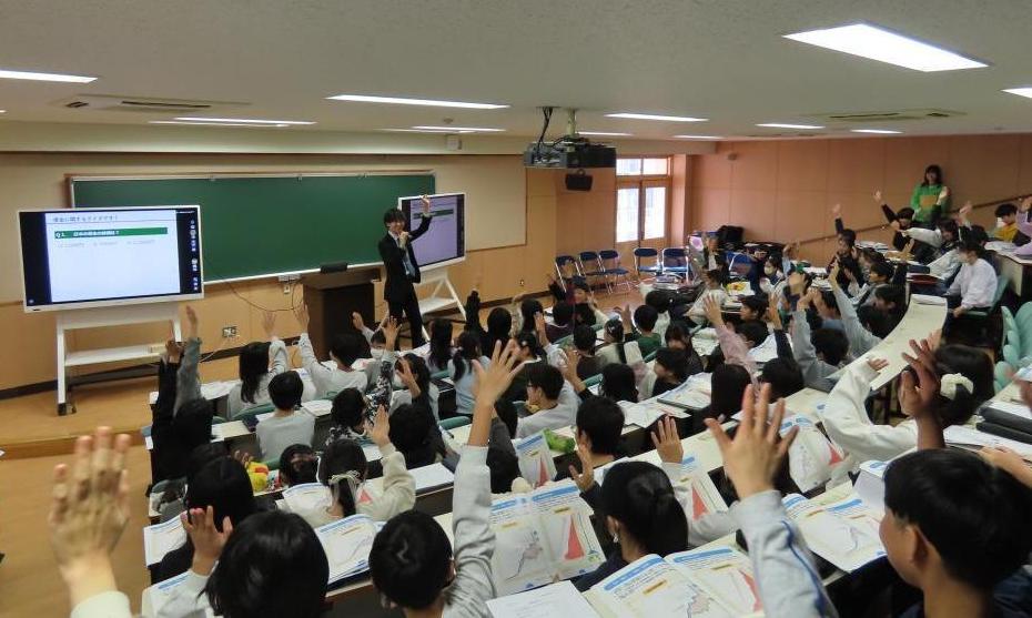 財務局職員による財政の講義で手を挙げてクイズに答える児童の様子