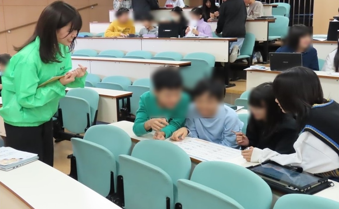 グループワークに取り組む児童と助言するアドバイザーの様子