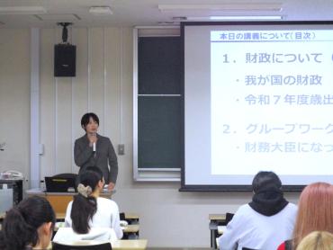 スクリーンに資料を投影し、講師が前に立って説明している様子