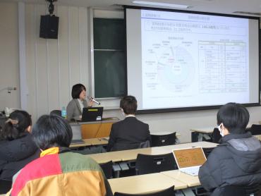 スクリーンの図表を示しながら、講師が解説している様子