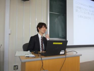 講師がパソコンとスクリーンを使い、前方で説明を行っている様子