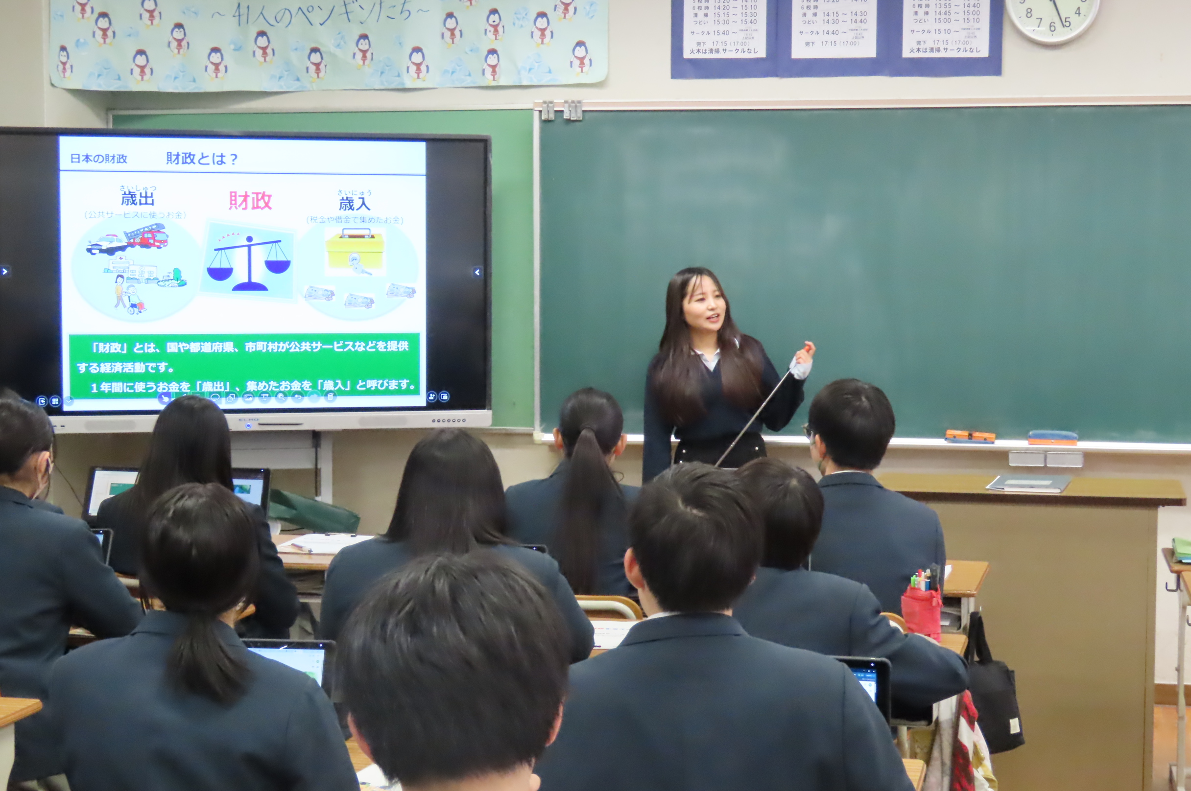 財務局職員がモニターに投影したスライドを使用し財政の説明を行っている様子