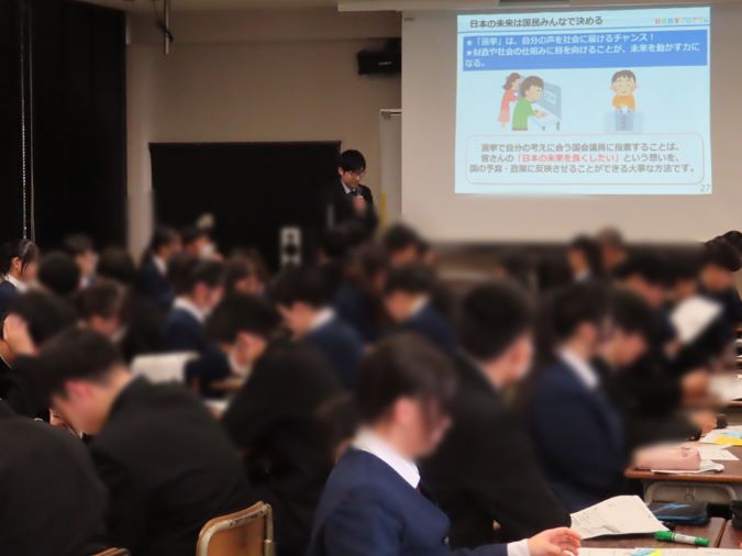 スクリーンに資料を投影し、講師が資料を説明しながら講義を行っている様子