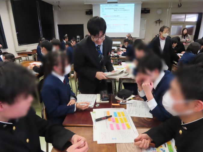 生徒が2050年の日本について付箋に書いた意見をもとに、数人ずつのグループで話し合っている様子