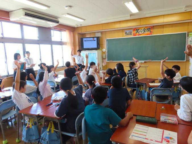 講義を聞いている生徒が、講師の質問に手を挙げて答えている様子