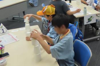 紙コップでピラミッドを作りに挑戦する子供たちの様子