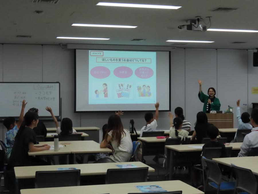 講師が出題するクイズに子供たちが手を挙げて答えている様子