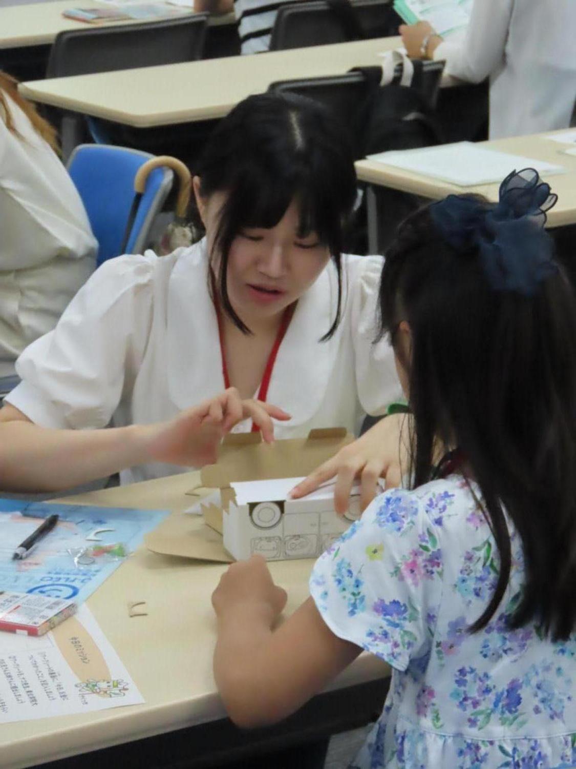 貯金箱を作る子どもとサポートする東北学院大学の学生