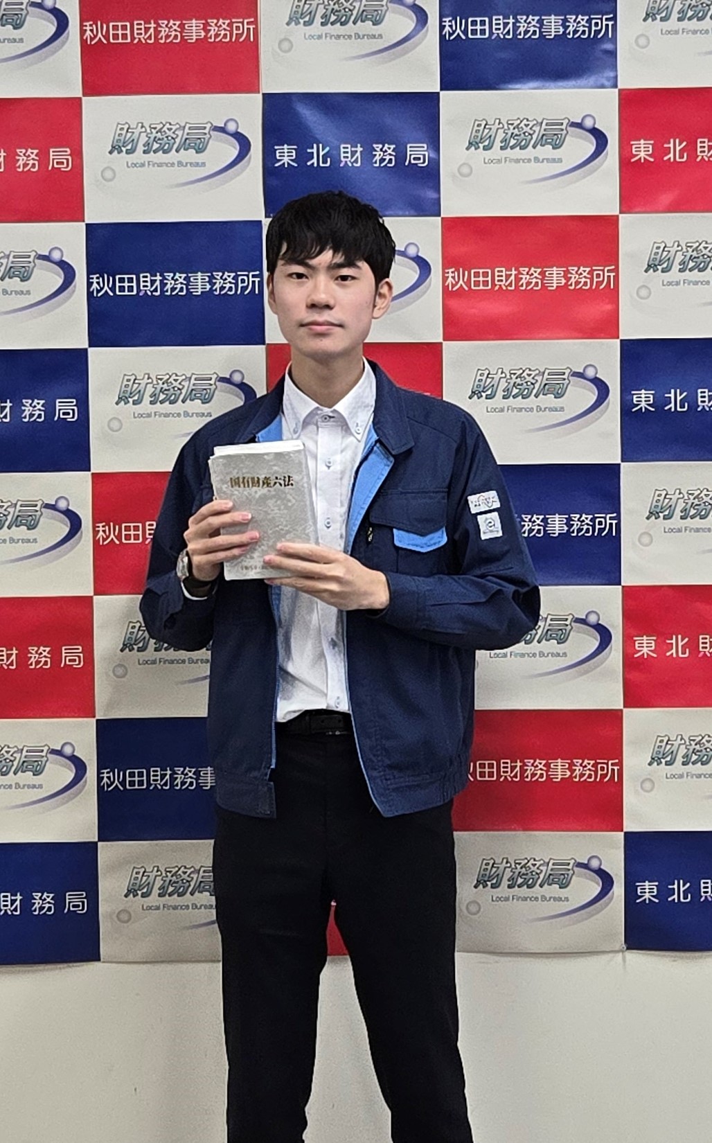 書籍を持っている秋田財務事務所管財課所属の若手職員