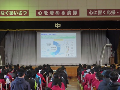 生徒がスクリーンに映し出された歳出の円グラフの説明を受ける画像