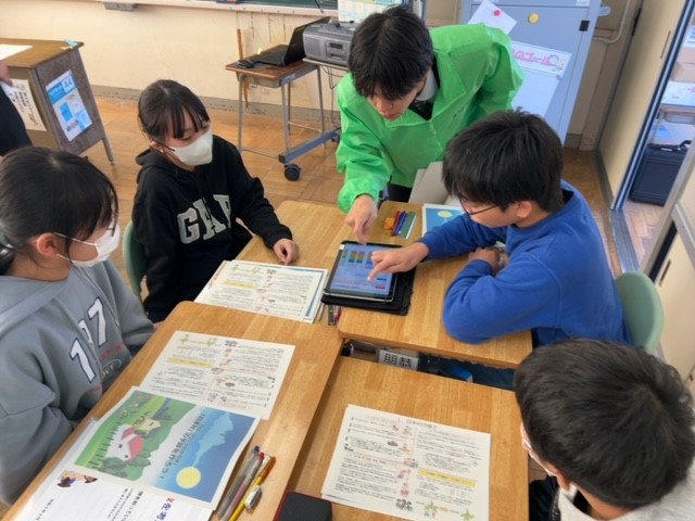 子どもたちが教室でグループに分かれ、タブレットを用いてグループワークをしている様子。