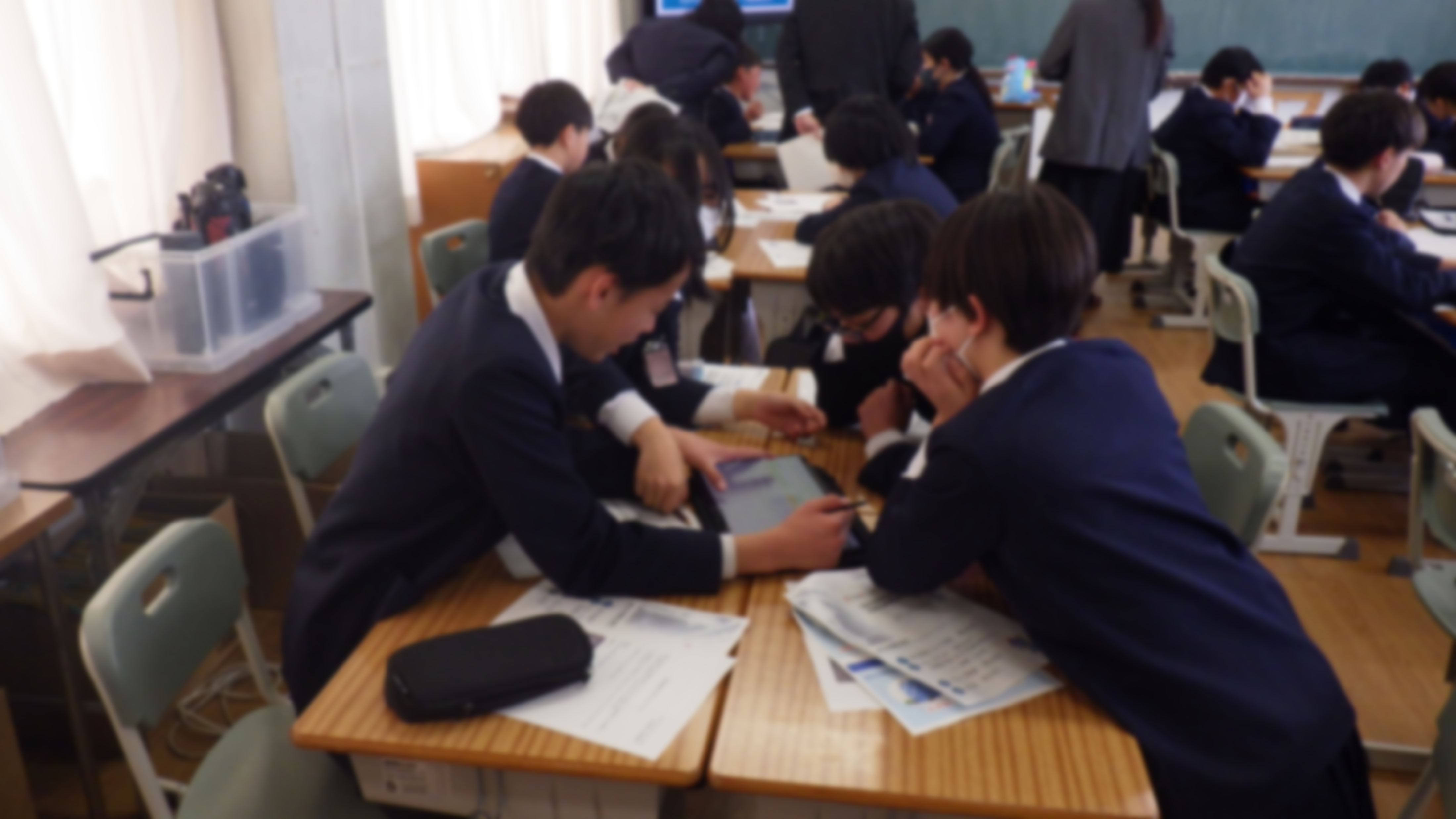 グループワークにてタブレットを操作しながら意見を出し合う児童の様子